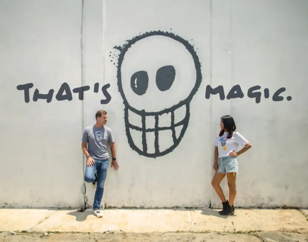 A couple in front of the Padre Azul skull mural